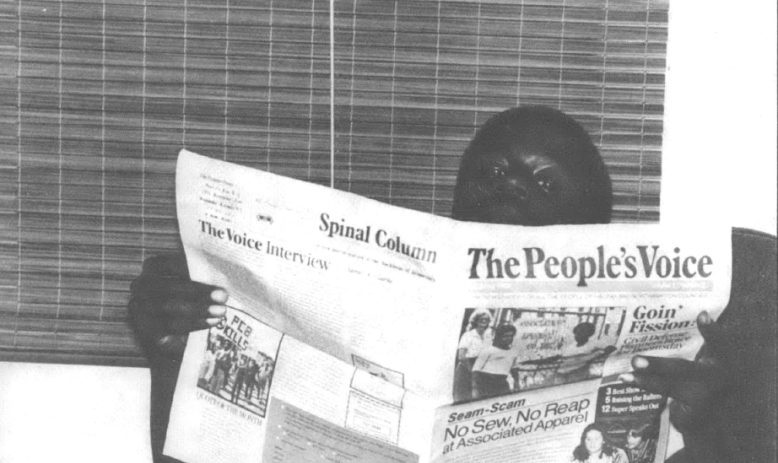 Black and white photo of Black man reading a newspaper