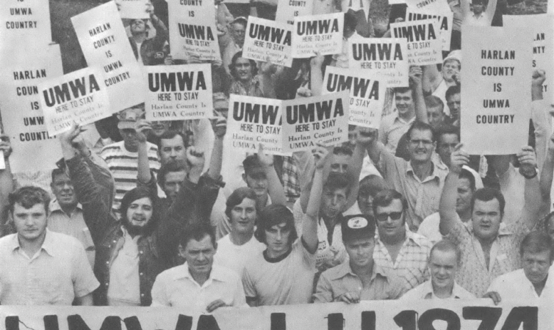 Photograph of people holding signs and a banner that reads "UMWA L.U. 1974"