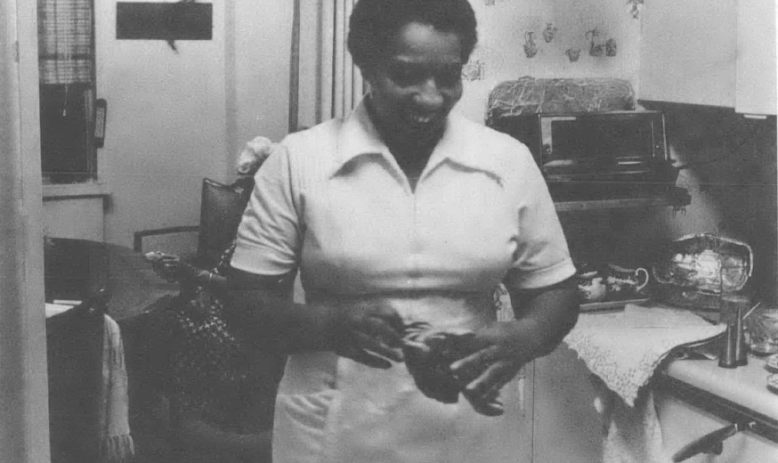 Black and white photo of Black woman standing in kitchen