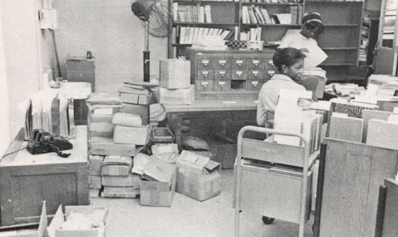Black and white photo of two Black women in a file room
