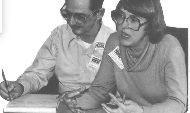 Photo cutout of two people sitting at table taking notes