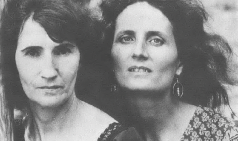 Black and white photo of two white women with long hair looking into the camera