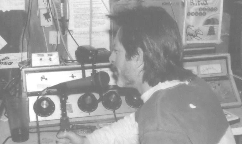 Man with mullet talking into a radio microphone