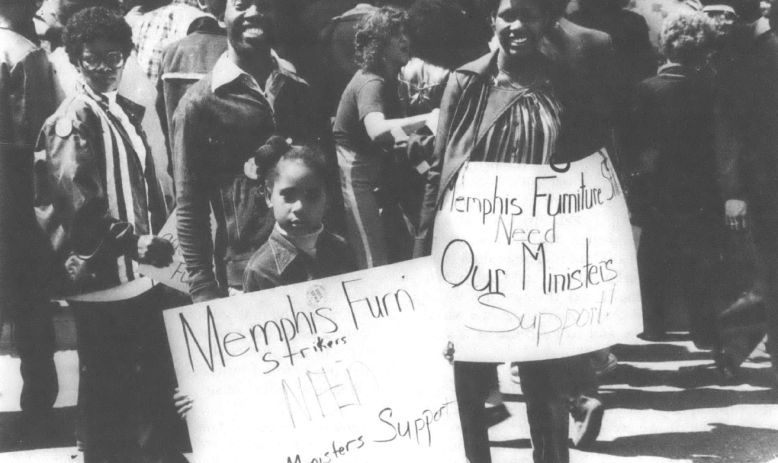 Black and white photo of group of demonstrators holding signs