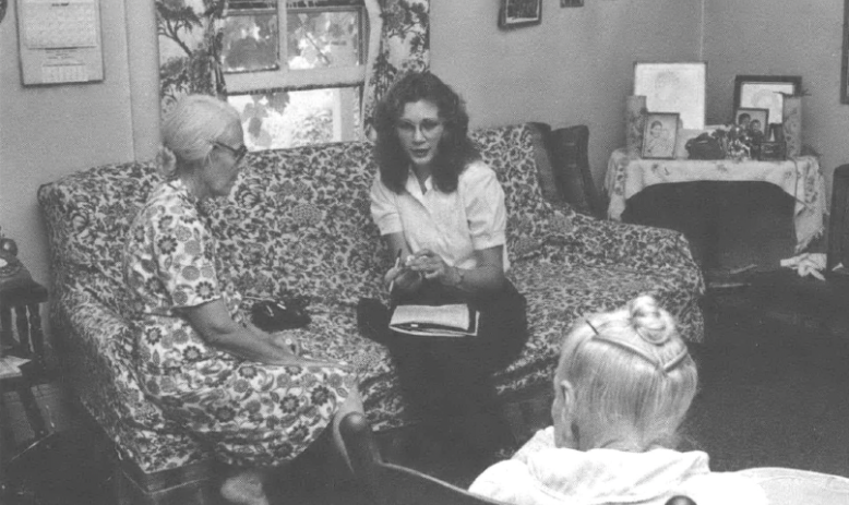 Photo of two women, one older and one younger, sitting on couch in living room 