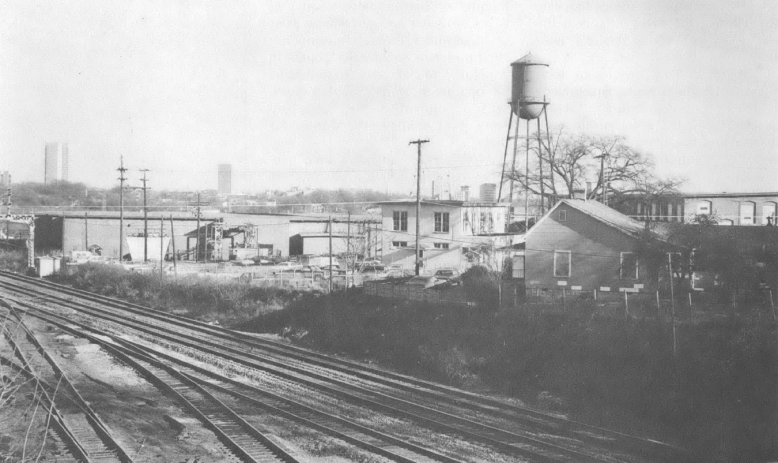 Black and white photo of railroad tracks and industrial landscape
