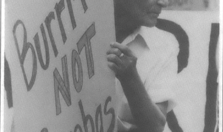 Old white man carrying sign that reads "burritos not bombs"