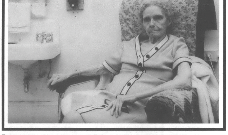Elderly woman seated next to sink