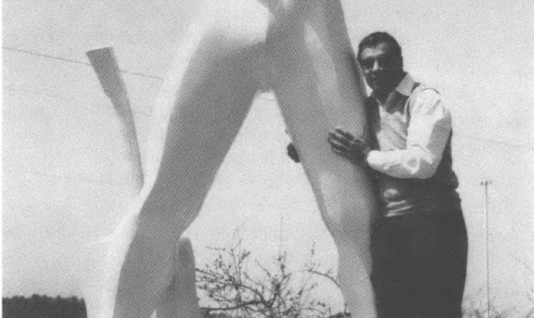 man poses with Elvis Presley statue
