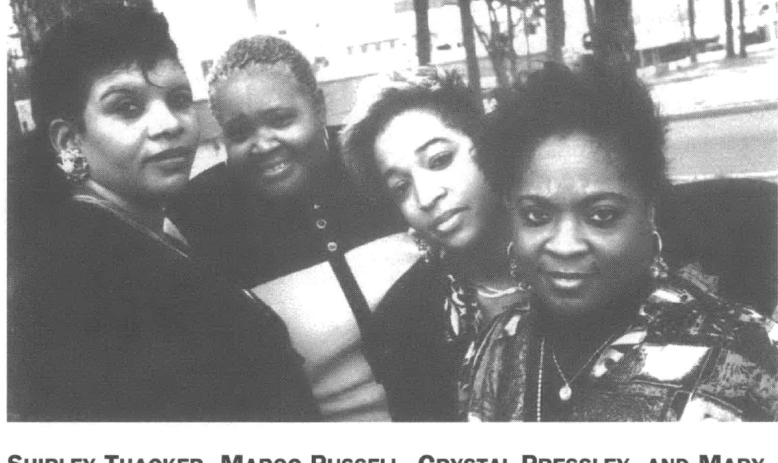 Four Black women looking into camera, standing outside