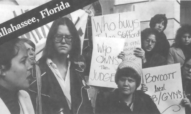 Black and white photo of people holding signs