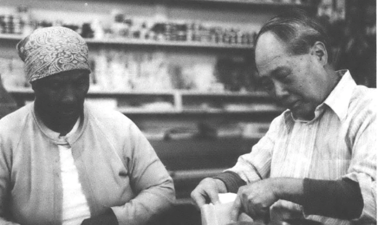 A black and white photo of Sui U. Chow at his store next to an unnamed Black woman