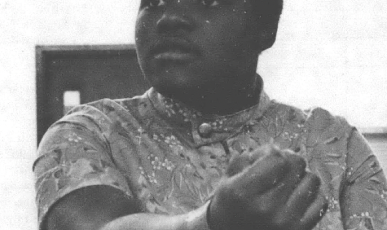 Black and white photo of Black woman sitting at table talking
