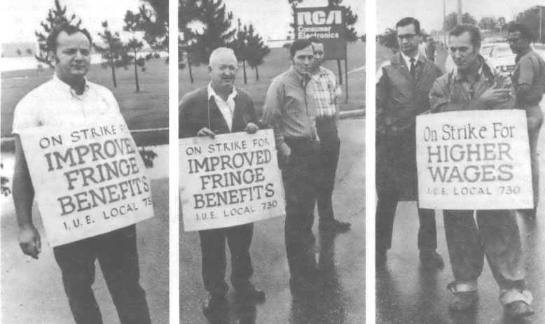 Black and white photo of three men standing with signs around their neck