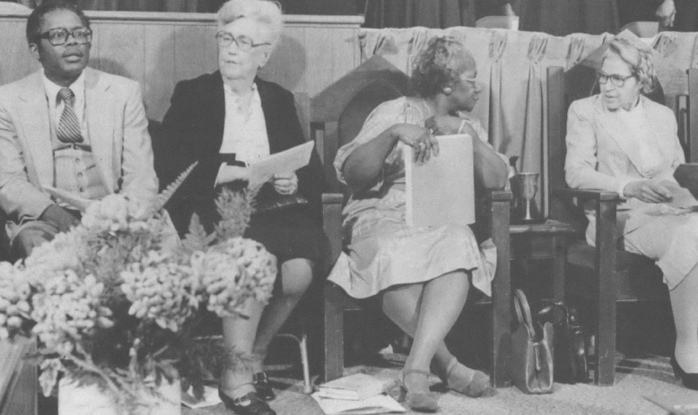 Black and white photo of Black leaders sitting on a stage 