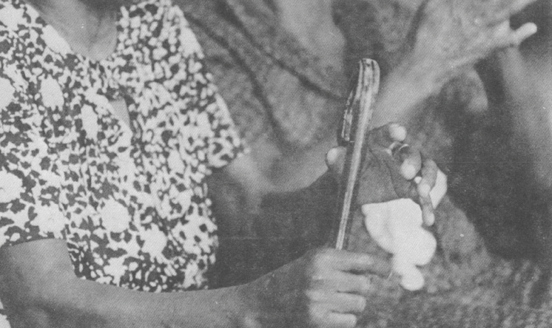 Black and white photo of two older Black women singing and clapping while seated 