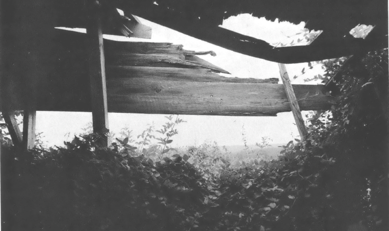 Black and white photo of deteriorating wooden building 