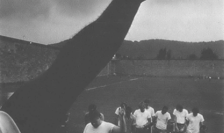 Black and white photo of group of people with outstretched arm in the forefront