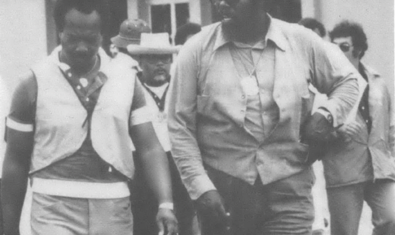 Black and white photo of two Black men in aviators walking down a street