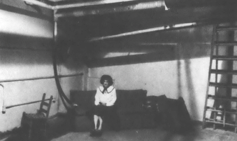 Marilyn Braun sitting in barren fallout shelter