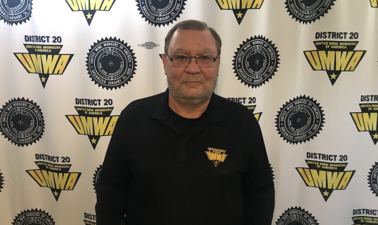 Larry Spencer stands in front of a UMWA logo backdrop
