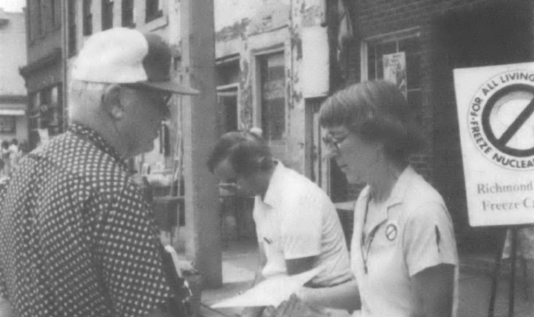 Woman handing paper out to man