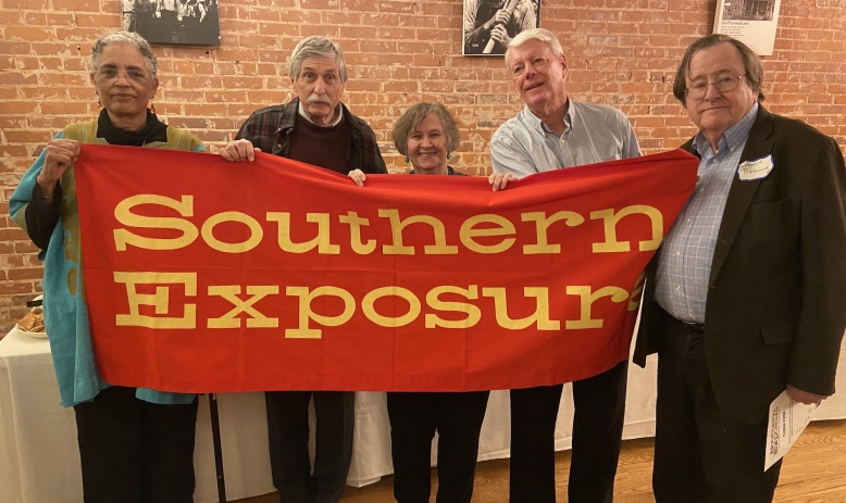 Five people holding up the Southern Exposure banner