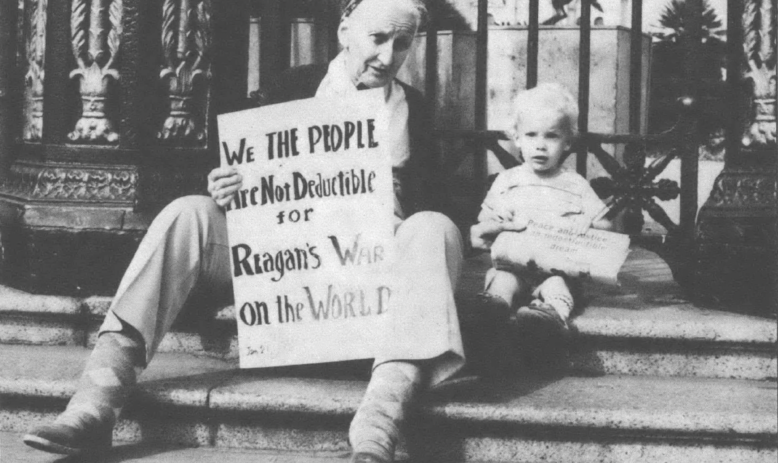 Woman, holding poster, and child sitting on steps