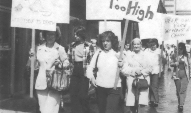 protesters carrying signs, including "Rates are too high"