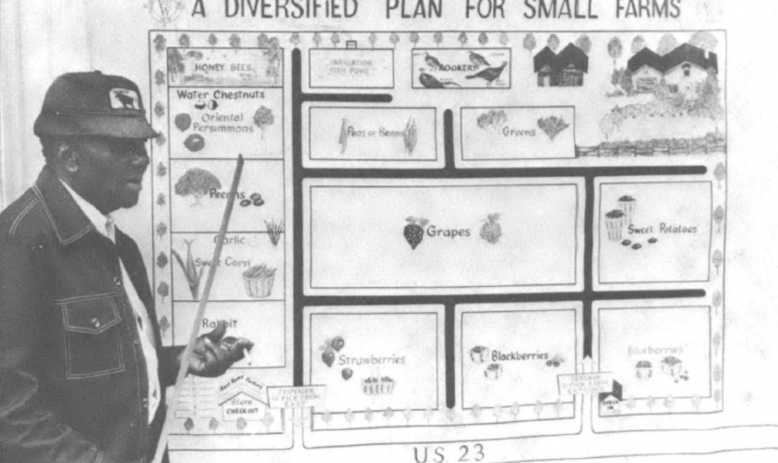 a man teaching from a board titled "a diversified plan for small farms"