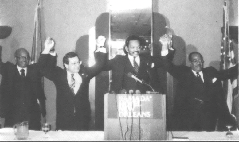 men holding and raising their hands, including Morial and Jesse Jackson