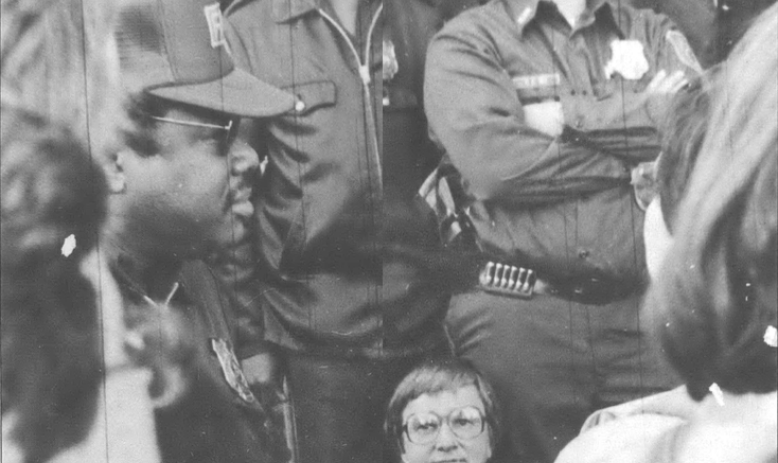 Women's Pentagon Action, 1981 - Police officers standing above a woman