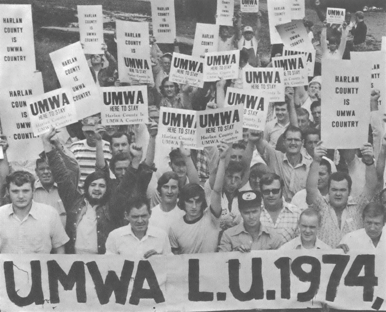 Photograph of people holding signs and a banner that reads "UMWA L.U. 1974"