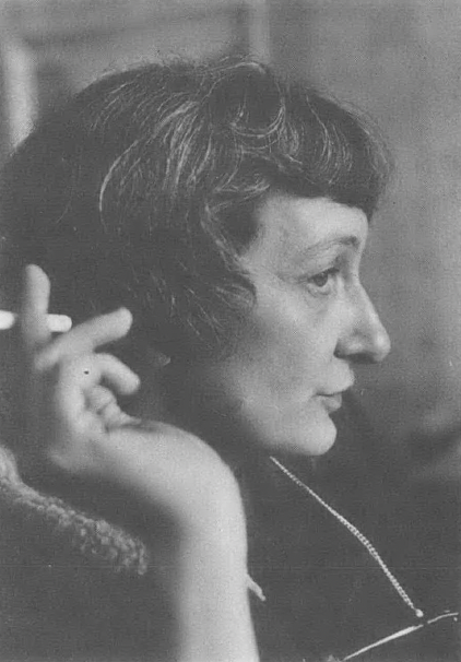 Black and white side profile of white woman holding a pen or cigarette in her hand, with bobbed haircut
