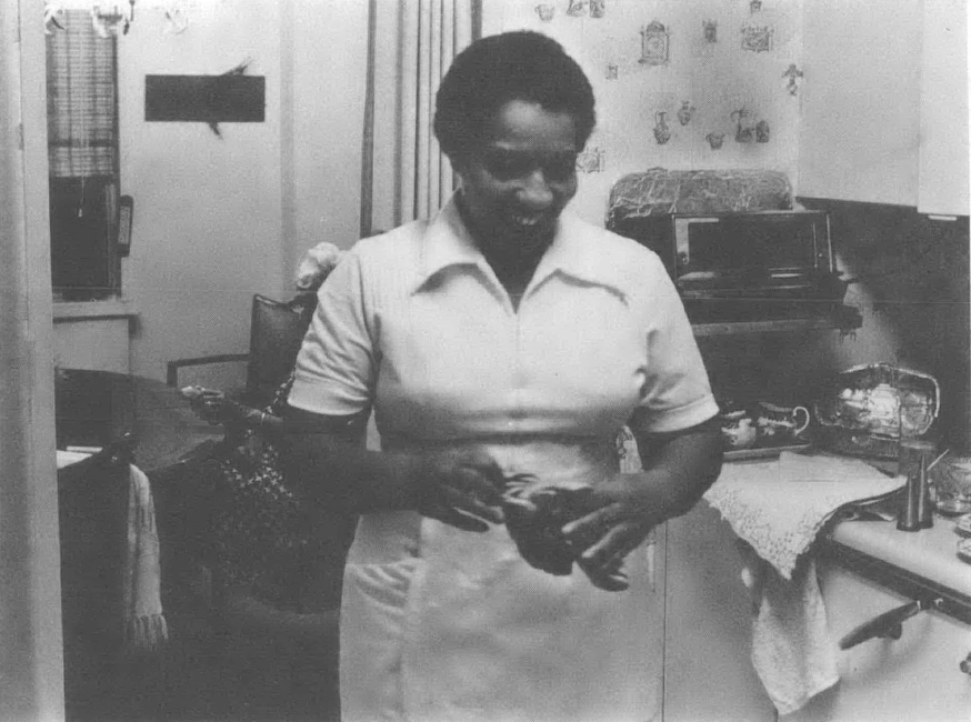 Black and white photo of Black woman standing in kitchen