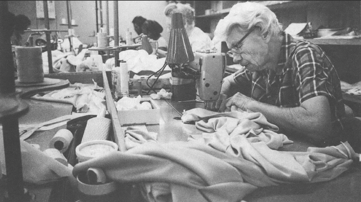 Black and white photo of older woman sewing