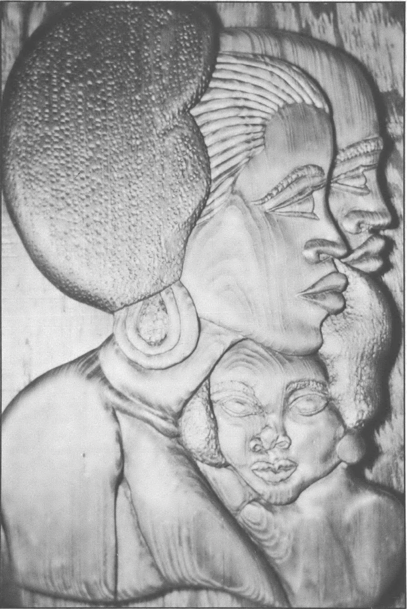 Photo showing woodcarving of side profile of a Black woman with two other faces
