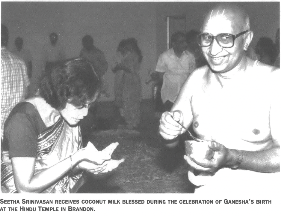Seetha Srinivasan receives coconut milk blessed during the celebration of Ganesha's birth at the Hindu temple in Brandon
