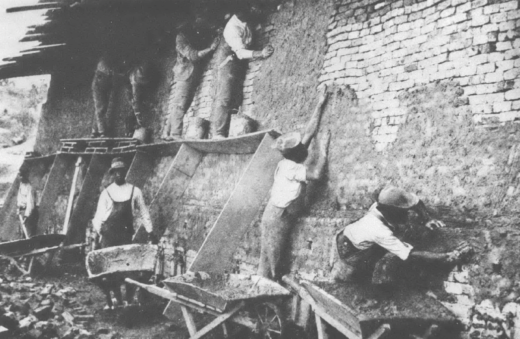 Black and white photo of Black men working on a building