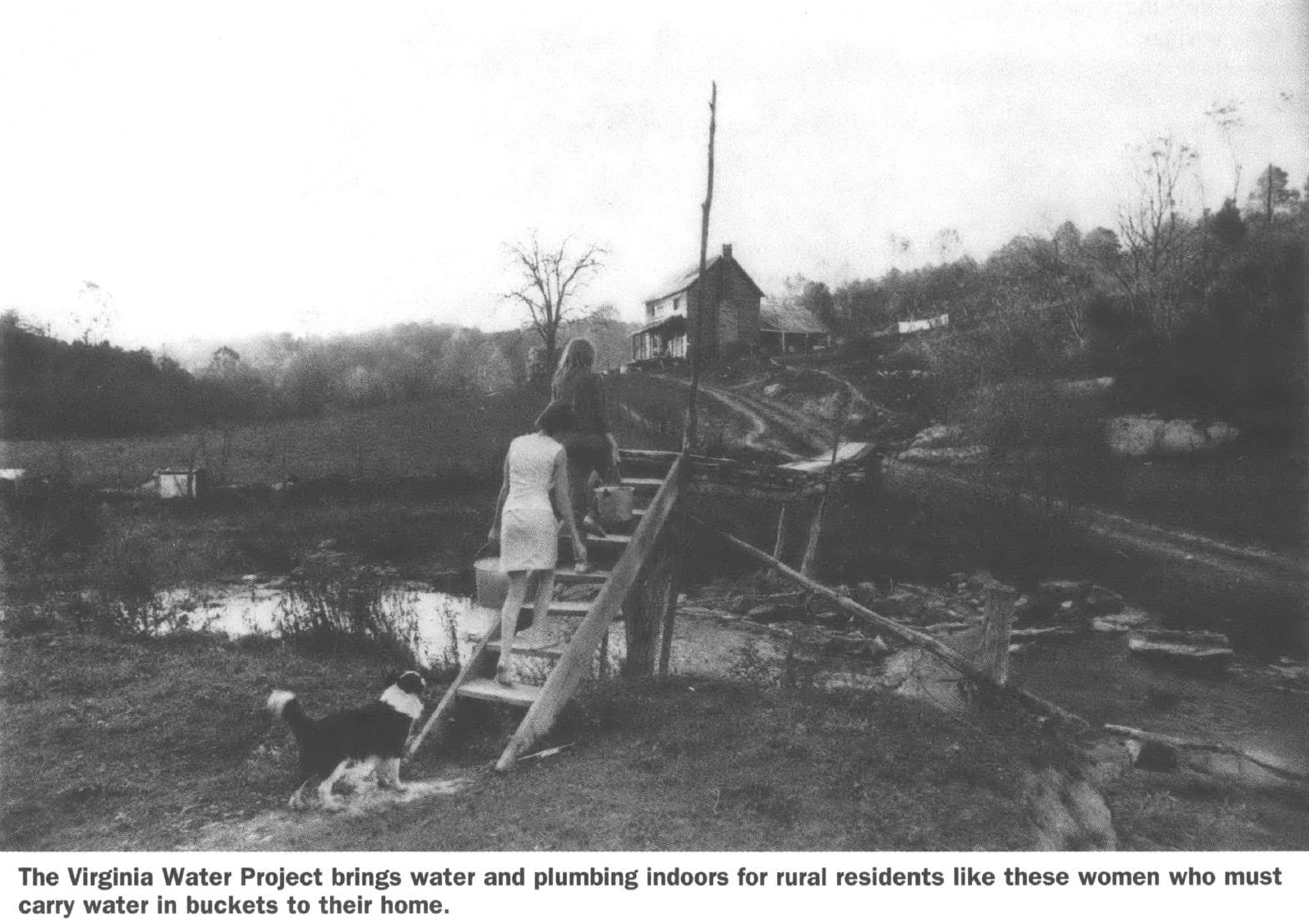 Women holding water pails climb stairs and a hill towards a house