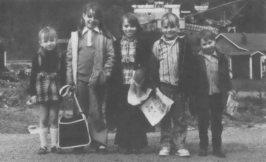 Black and white photo of five children standing in a row looking at the camera