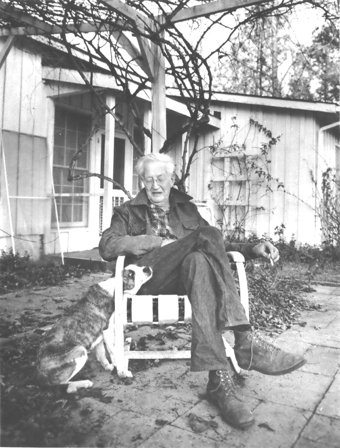 Clifford Durr sits with dog outside of house