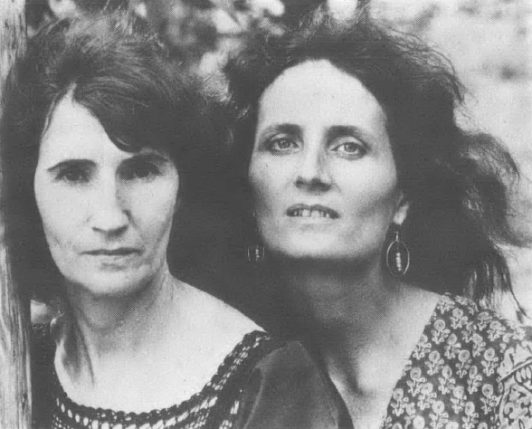 Black and white photo of two white women with long hair looking into the camera
