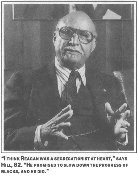 Man in a suit, bald, gesticulating with his hands, glasses, indoors