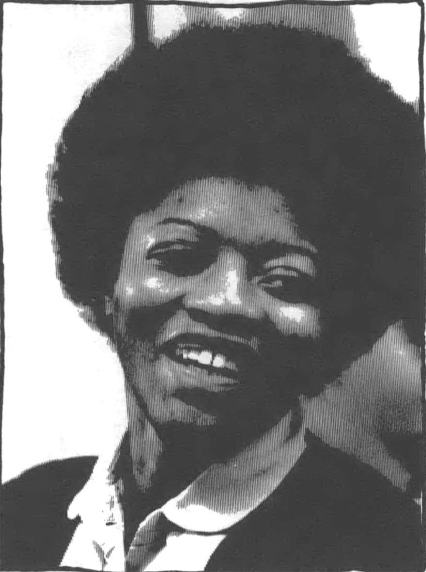 A black and white photo of Joan Little, a young Black woman smiling and wearing an Afro and collared shirt