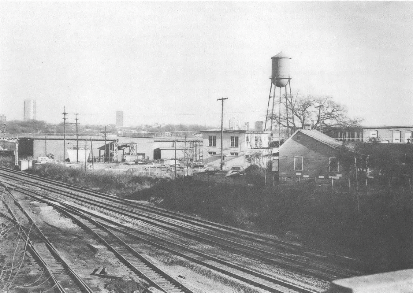 Black and white photo of railroad tracks and industrial landscape