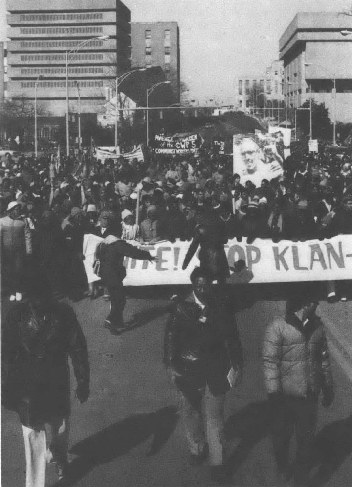 Black and white photo of demonstrators holding anti-Klan sign