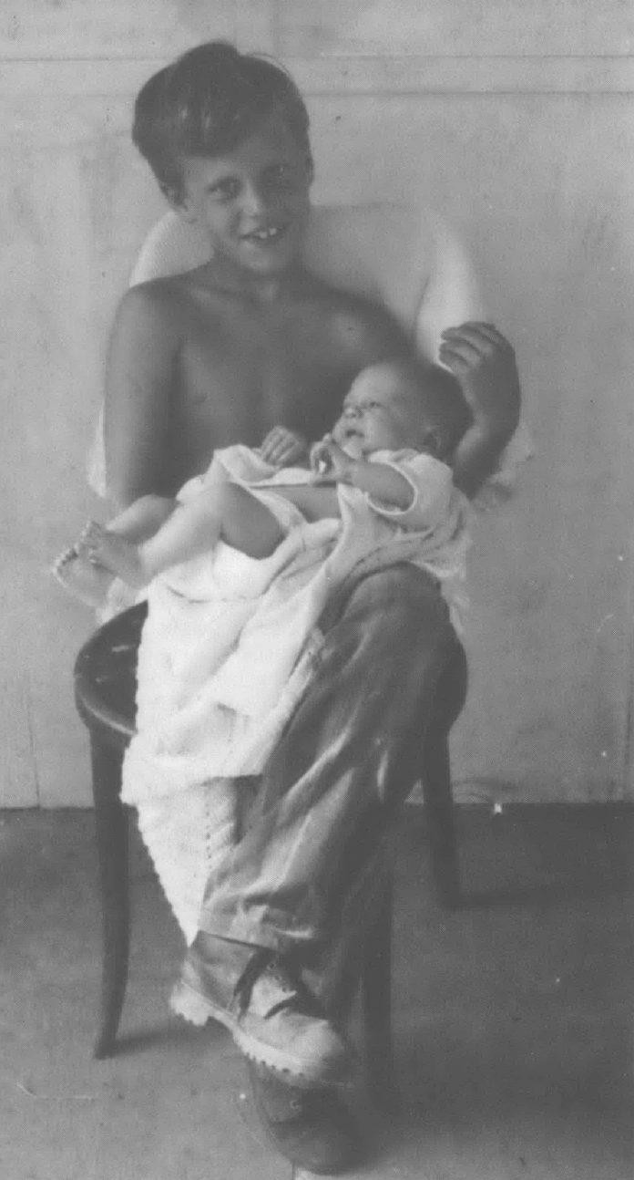 Black and white photo of child holding a baby