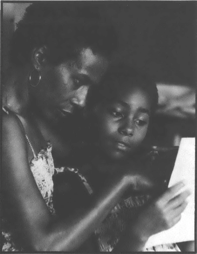 Black and white photo of Black woman and child looking at a piece of paper 
