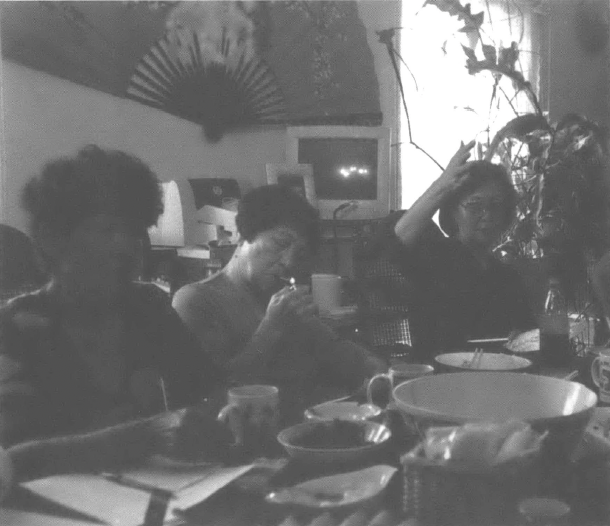 Three Japanese women sit at a table in a home